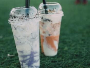 Photo of two milkshakes in plastic cups on the grass