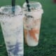 Photo of two milkshakes in plastic cups on the grass